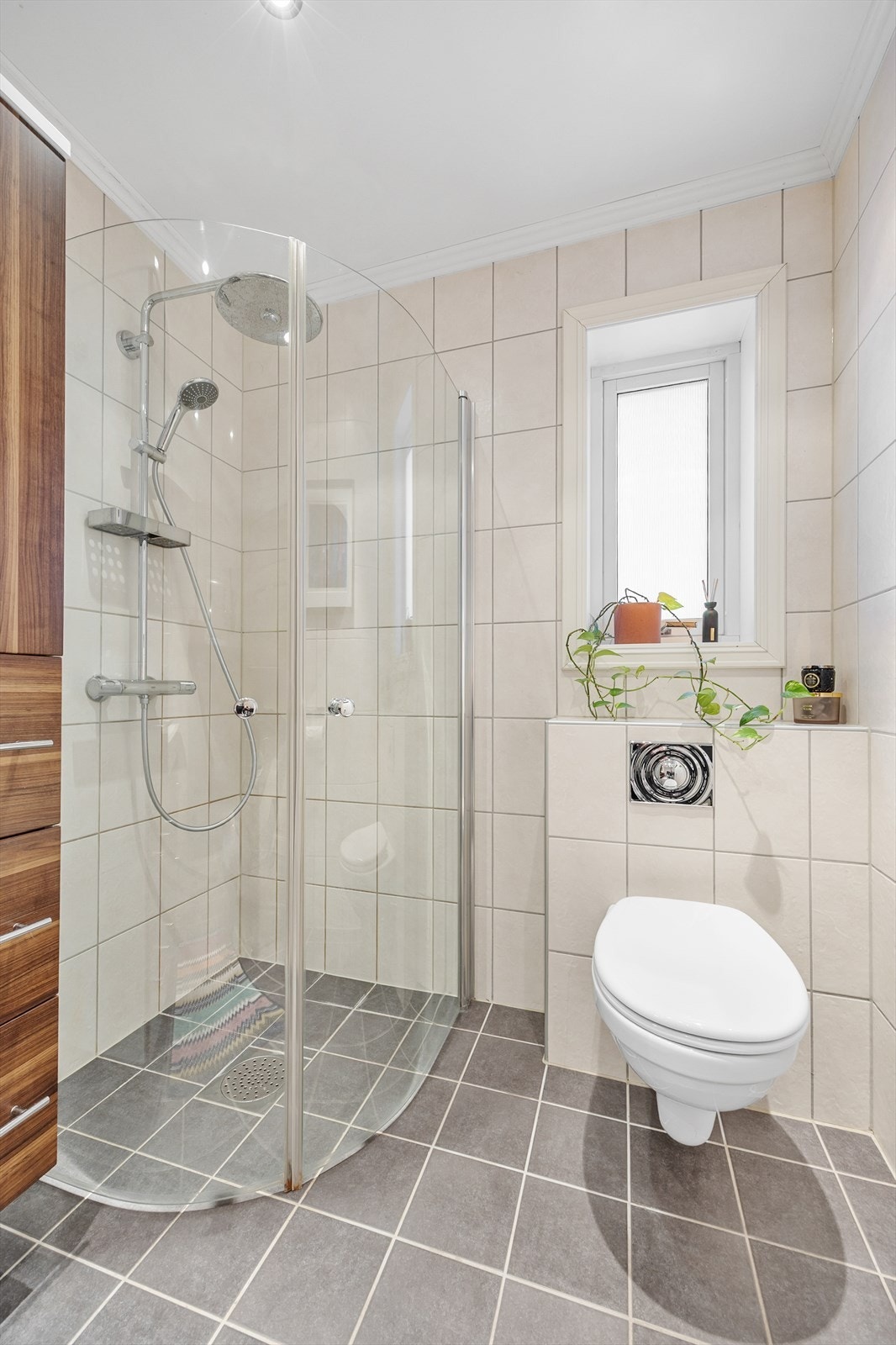 Badet innehar vegghengt toalett, servant med skuffer og dusjnisje med innfellbare glassdører. Galleribilde