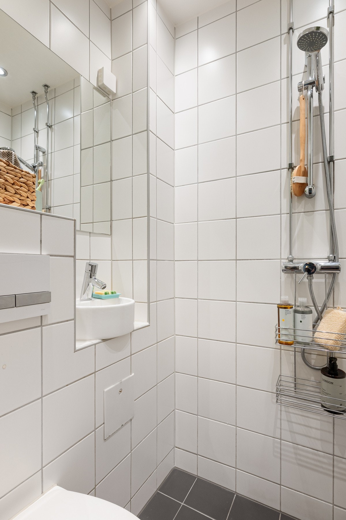 Badet er innredet med servant, vegghengt skap, toalett og dusjhjørne. Galleribilde