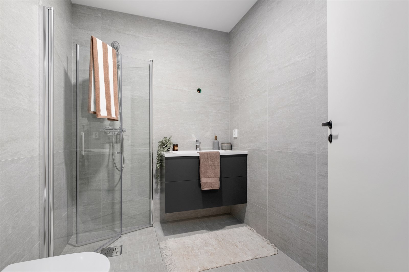 Badet i tilknytning til soverommet er på 5m². På alle bad får du gulv og vegger med 60X60cm flis fra Cæsar Core Island. I dusjsoner leveres mosaikkflis. Galleribilde