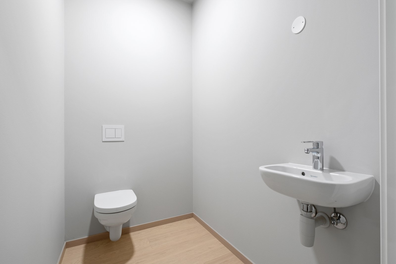 Toalettet i entreen er praktisk innredet med både veggmontert toalett og servant. Galleribilde