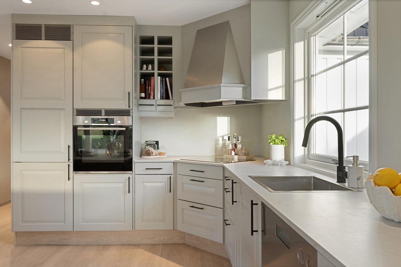 Kjøkkenet har en tidløs innredning med profilerte fronter og ble oppgradert i 2021 med ny benkeplate, oppvaskkum og platetopp. Galleribilde