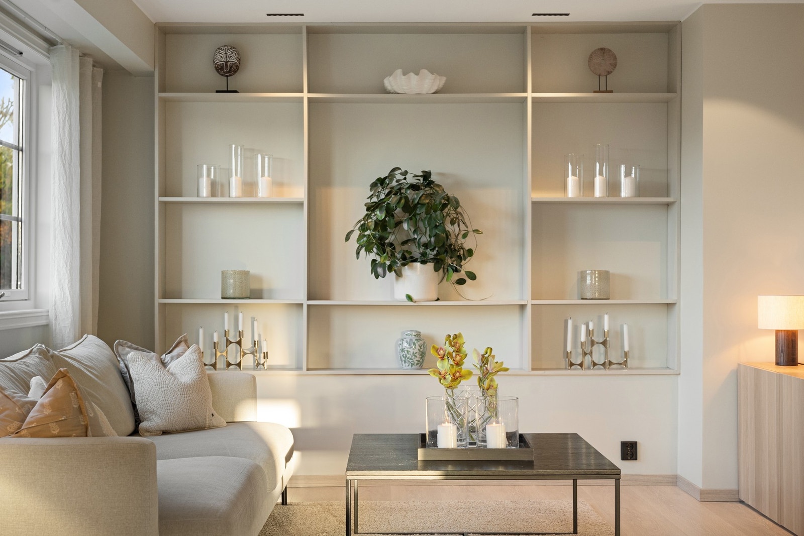 Skreddersydd reolvegg gir stuen et moderne og gjennomført uttrykk, samtidig som den byr på både oppbevaring og dekorative flater. Galleribilde