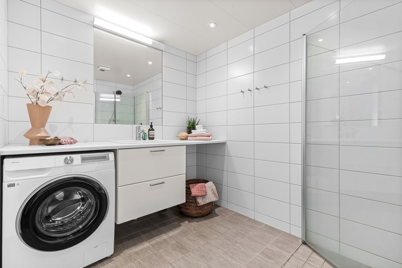 Innredningen består av servantskap med skuffeseksjon, speil, vegghengt toalett og dusjhjørne med svingdører. Galleribilde