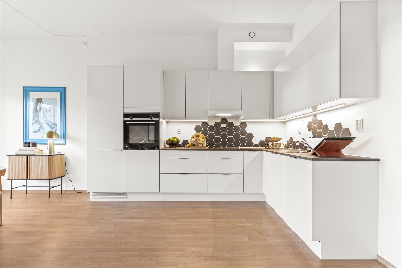 Stilrent kjøkken fra byggeåret med en funksjonell og praktisk utforming med rikelig med skap- og benkeplass. Galleribilde