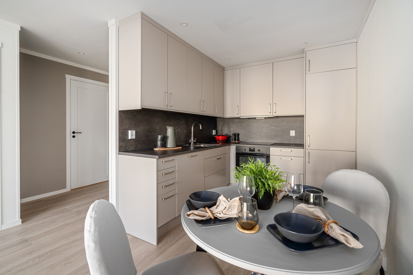 Selv om man har åpen løsning mellom stue og kjøkken, så er kjøkken inn i en egen krok slik at man allikevel får et skille. Galleribilde