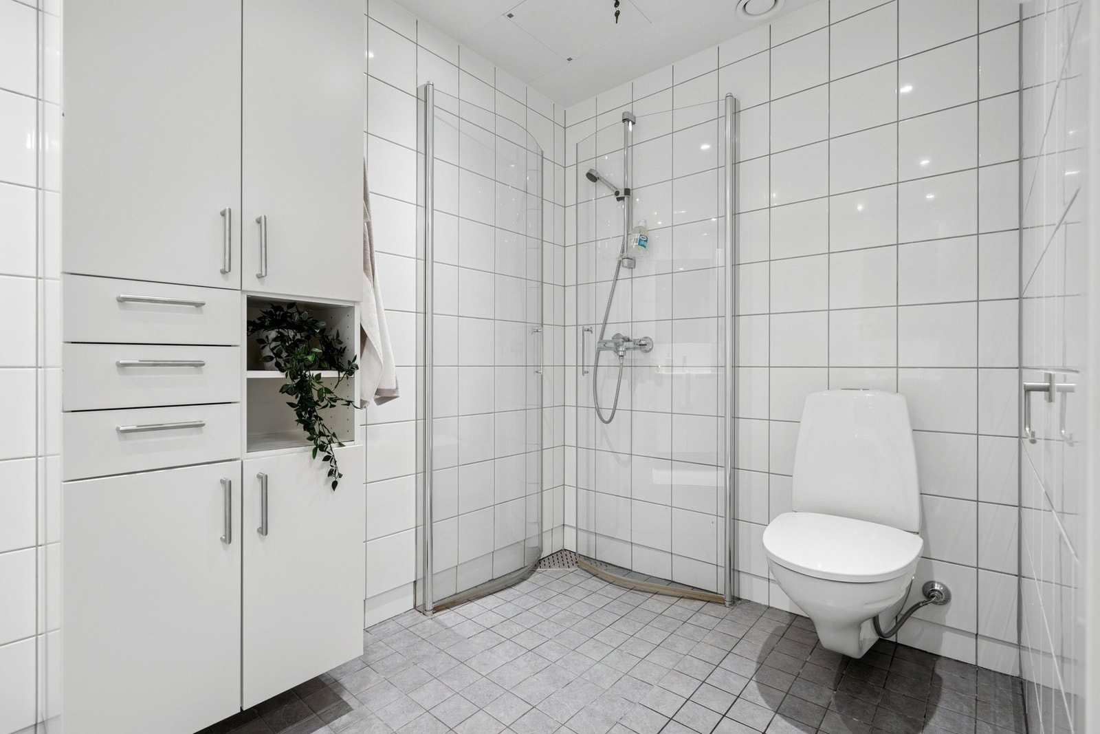 Badet er innredet med nedfelt servant, vegghengt toalett og dusjvegger/hjørne. Galleribilde