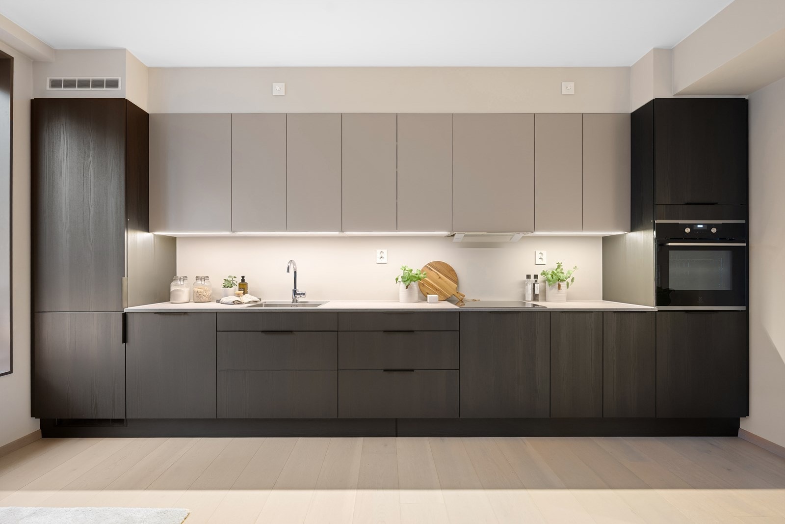 Kjøkkenet er levert av HTH. Her er det lagt opp til både mørke og lyse fronter - det er godt med lagringsplass i skuffer og skap samt integrerte hvitevarer. Galleribilde