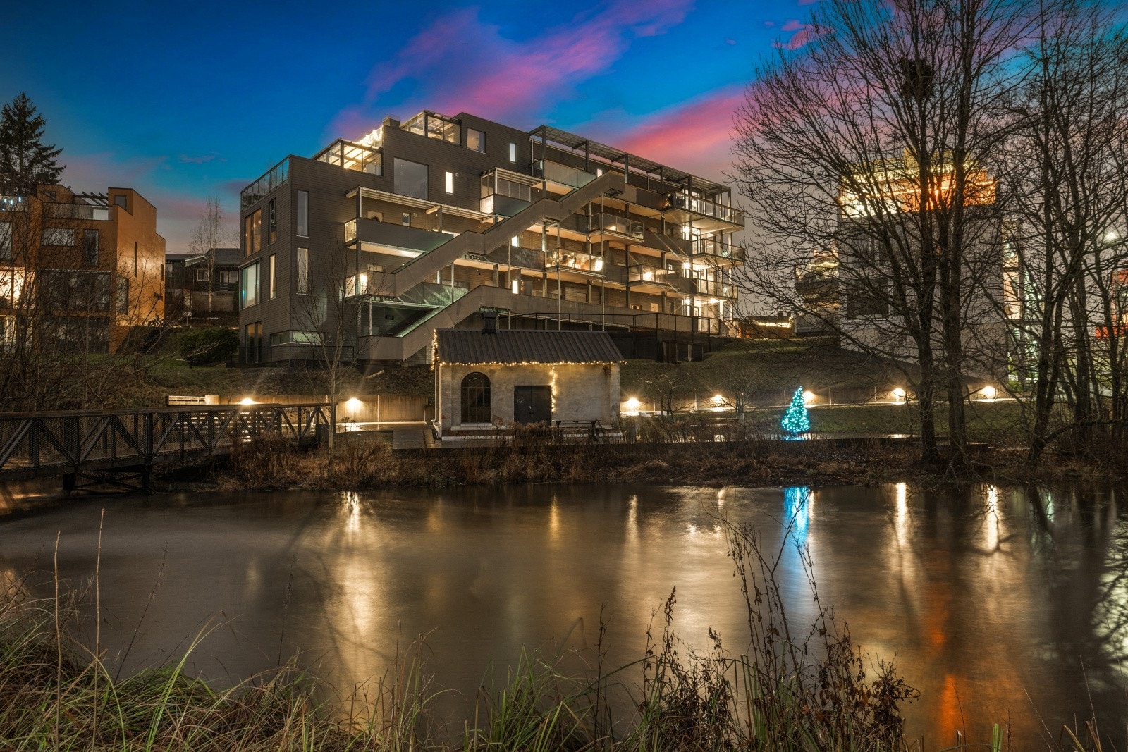 Området er vakkert opplyst om kvelden, med lys som reflekteres i vannet og gir en magisk stemning. Galleribilde