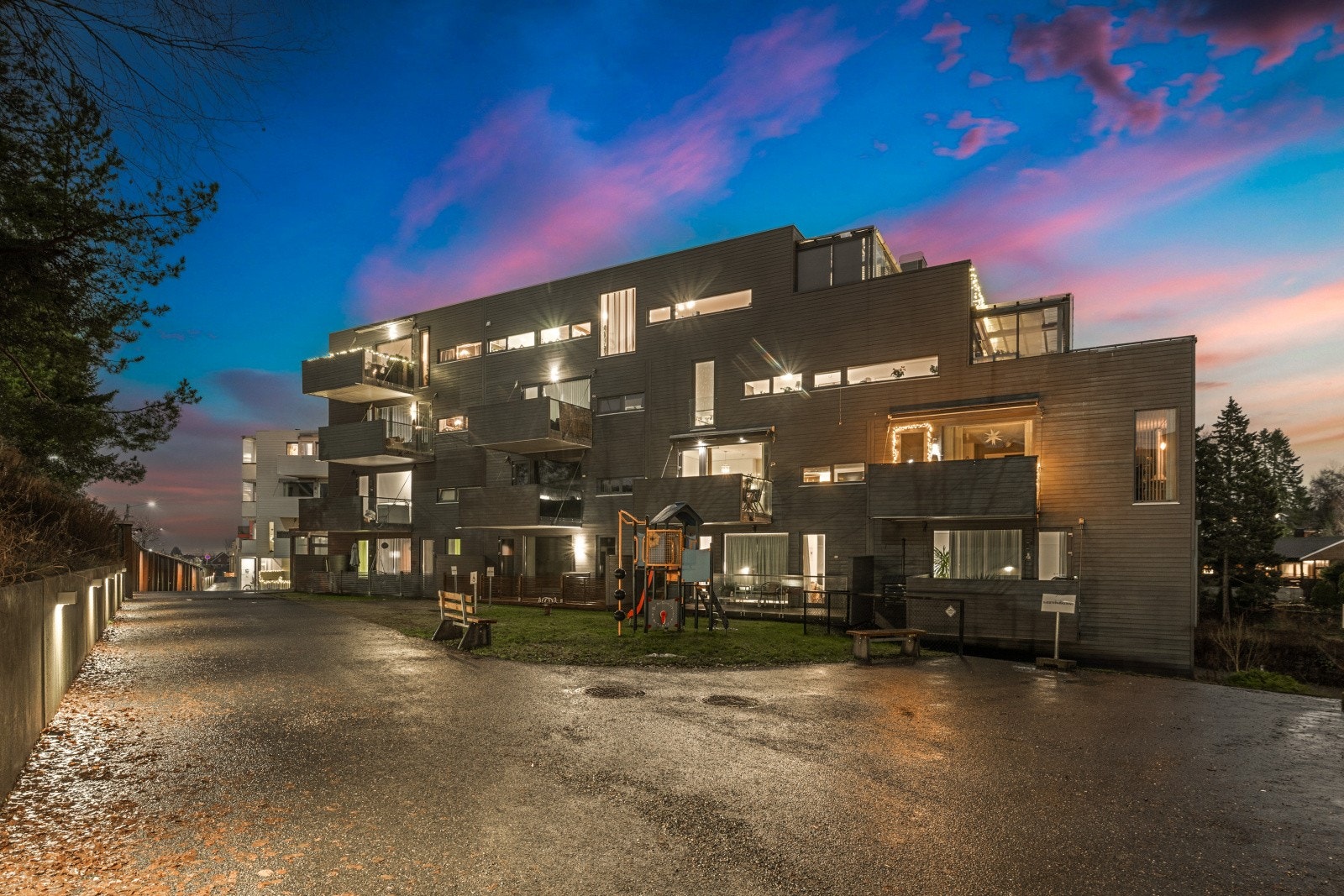 Boligblokken har moderne fasade med store vindusflater. Galleribilde