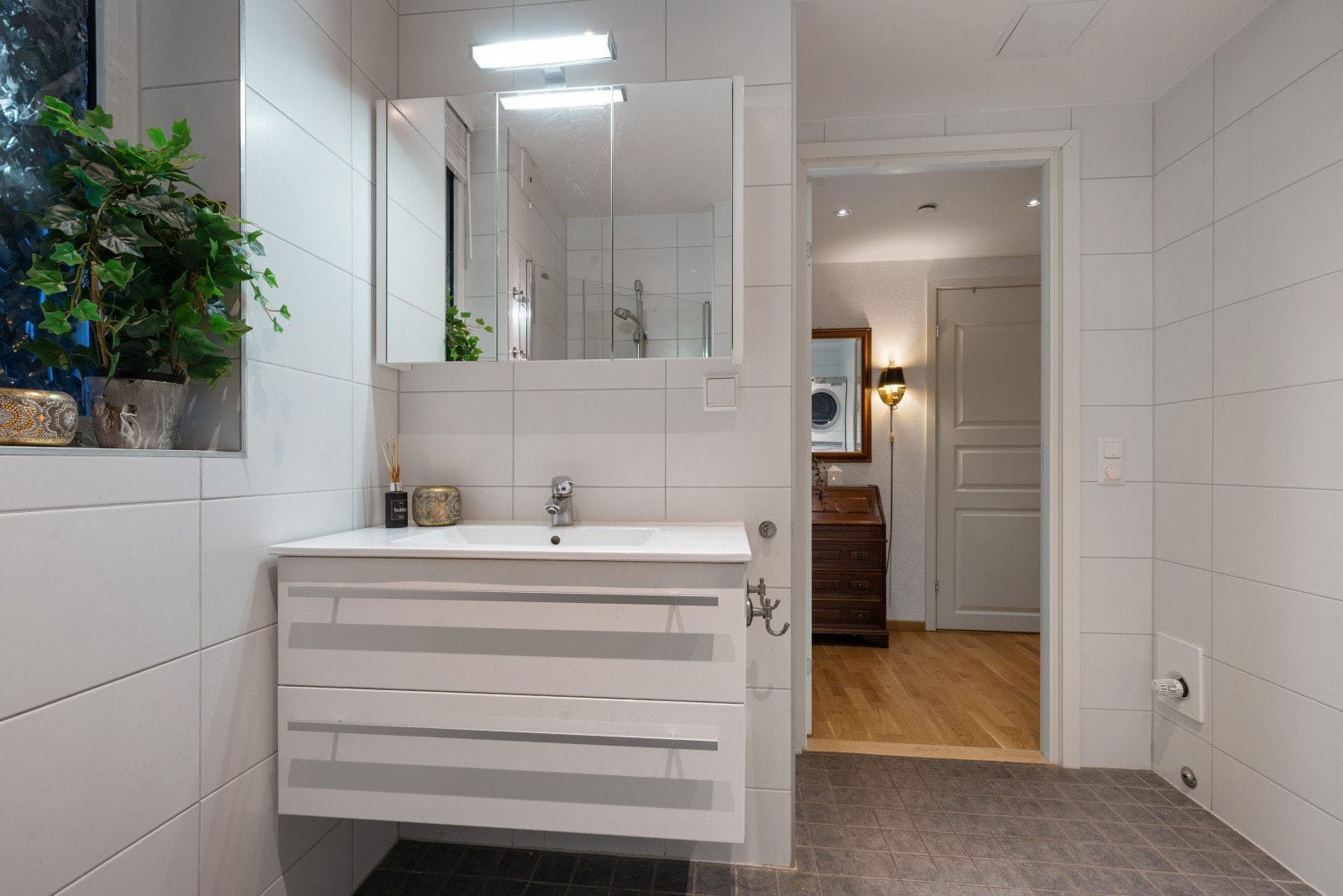 Innredning med glatte fronter og speilskap gir praktisk oppbevaring på badet. Galleribilde