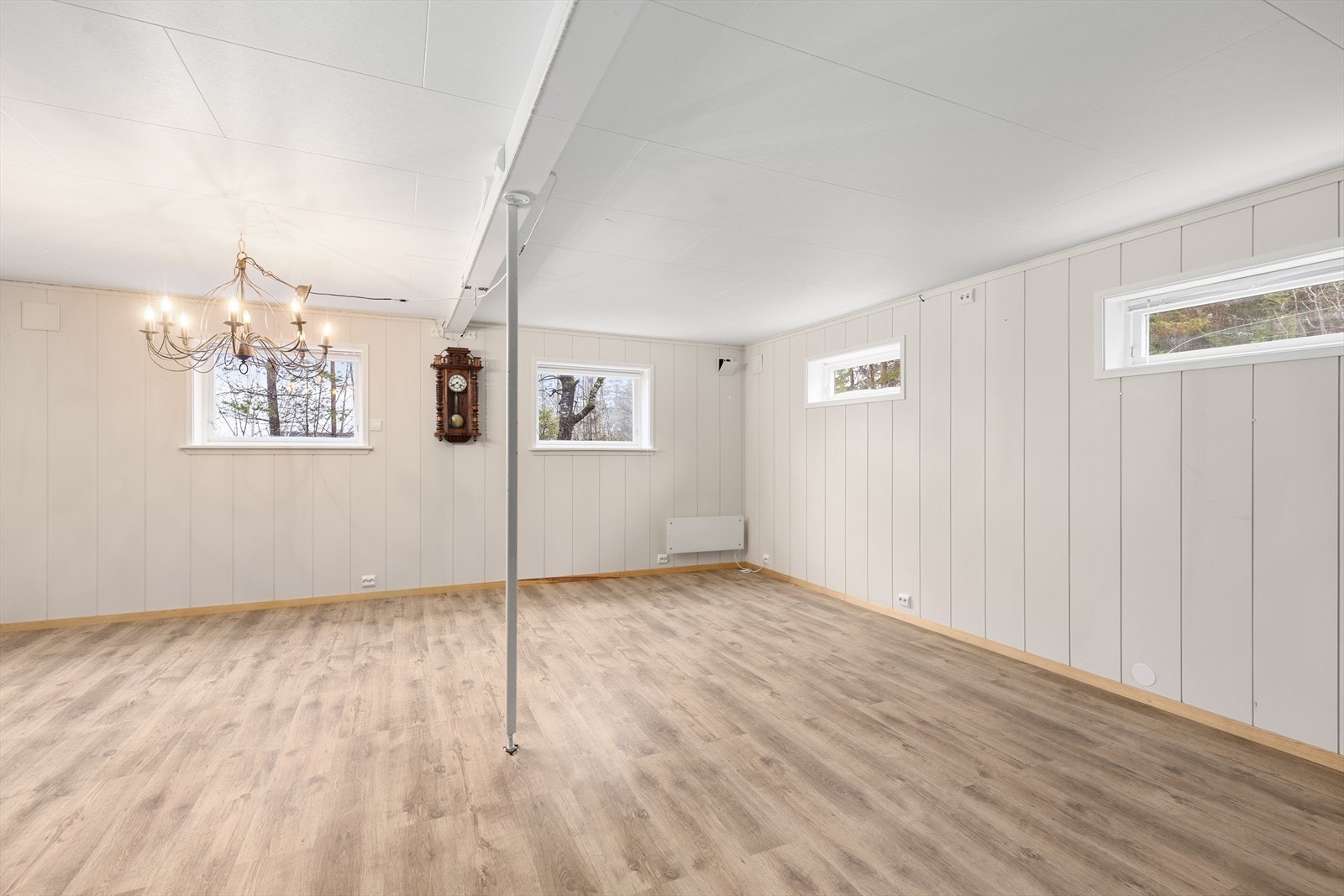 Kjellerstuen er lys og hyggelig, og har vedovn og god plass til møblement. Det er laminat på gulv og malte plater/ skifer på vegger. Kjellerstuen er innredet om omgjort fra tidligere disponibelt rom uten godkjennelse fra kommunen. Galleribilde