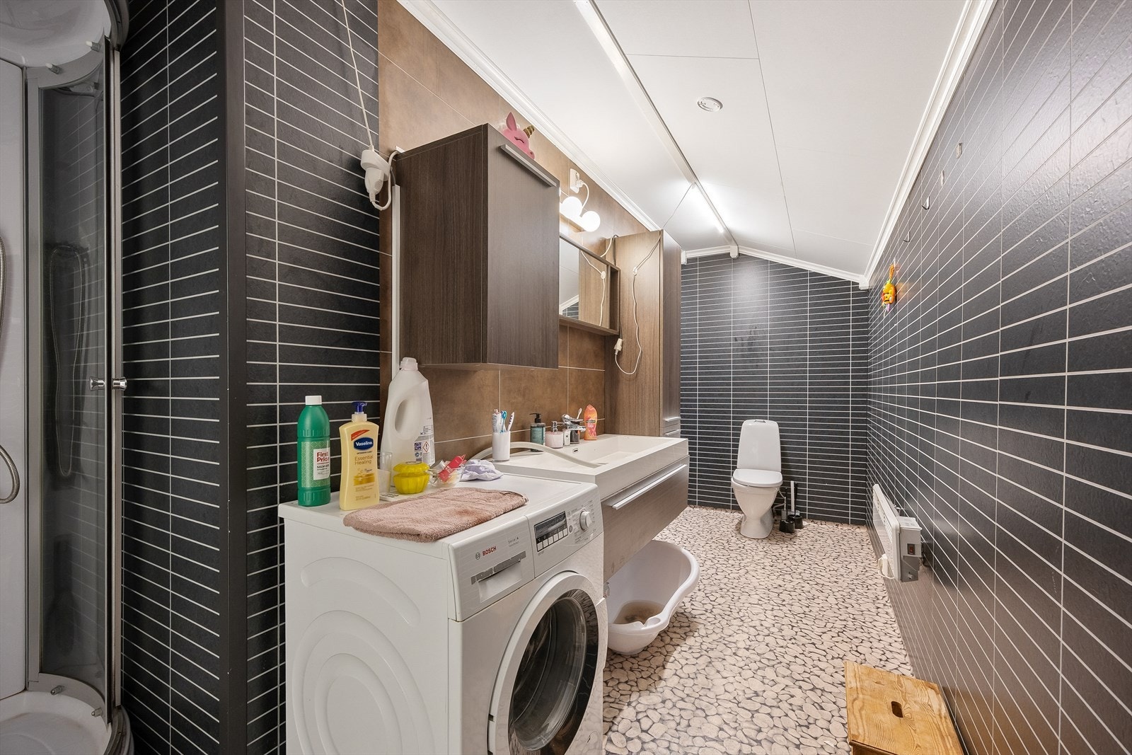 Badet i 2. etasje byr på dusj, wc, baderomsinnredning med servant og opplegg til vaskemaskin. Galleribilde