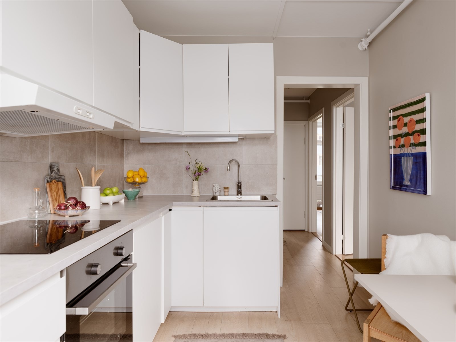 Kjøkkenet er tidløst med hvite fronter og grå benkeplate. Galleribilde