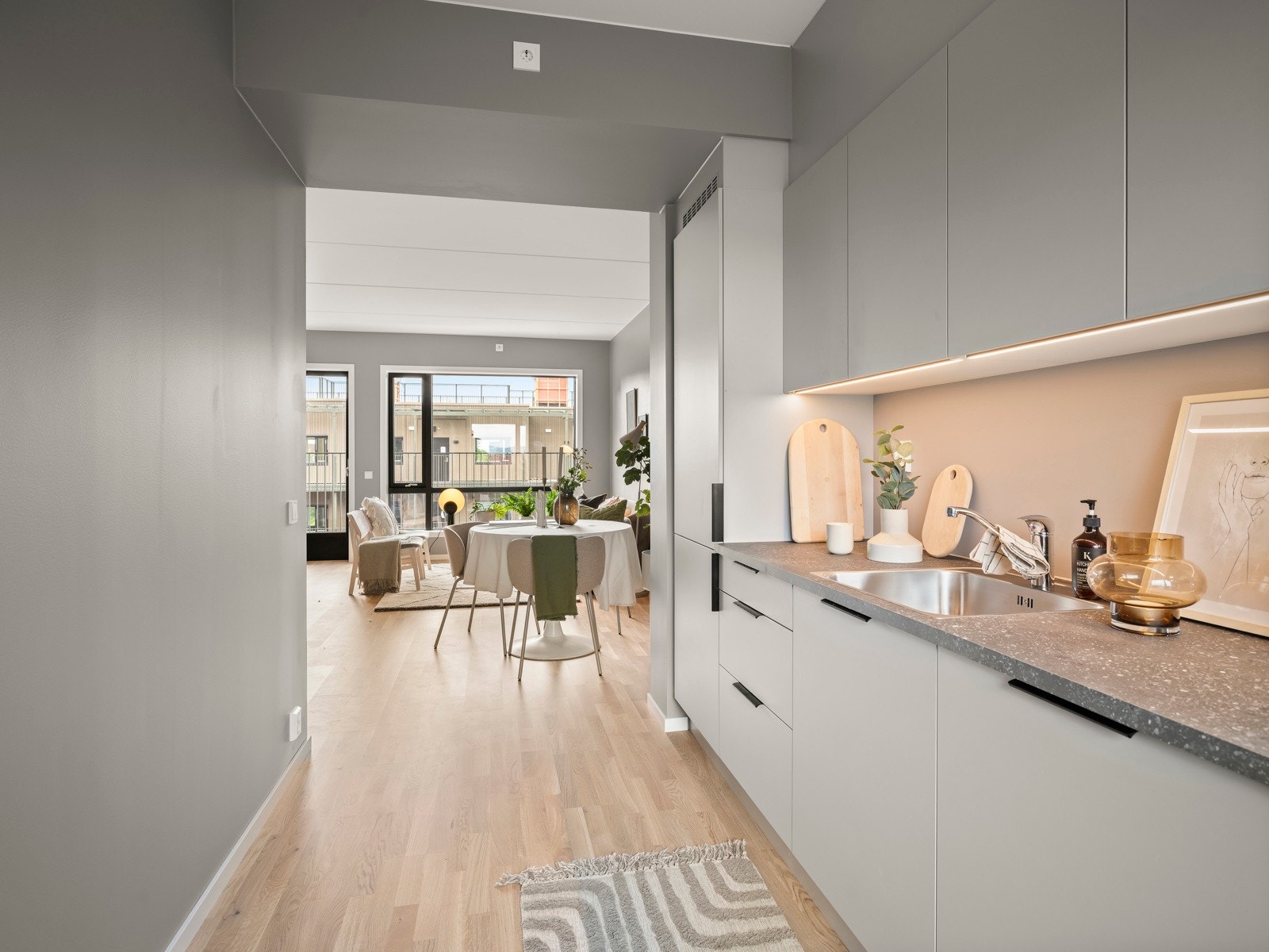 Kjøkkeninnredning fra HTH, tidsriktig med grå, glatte fronter. Komplett utstyrt med integrerte hvitevarer . Galleribilde