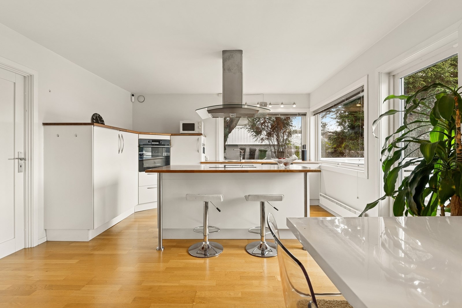 Kjøkkenet har lyse, slette fronter og integrerte hvitevarer. Her finner du rikelig med benke- og skapplass, i tillegg til en praktisk kjøkkenøy med platetopp og takmontert opptrekksvifte. Galleribilde