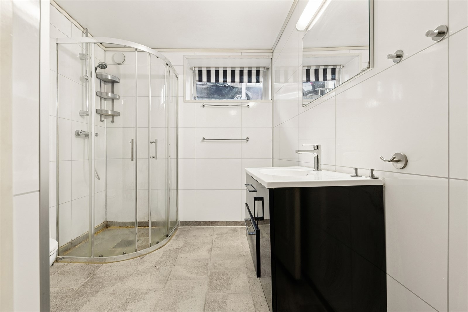 Badet er utstyrt med dusjhjørne, vegghengt toalett og innredning med nedfelt servant. Galleribilde