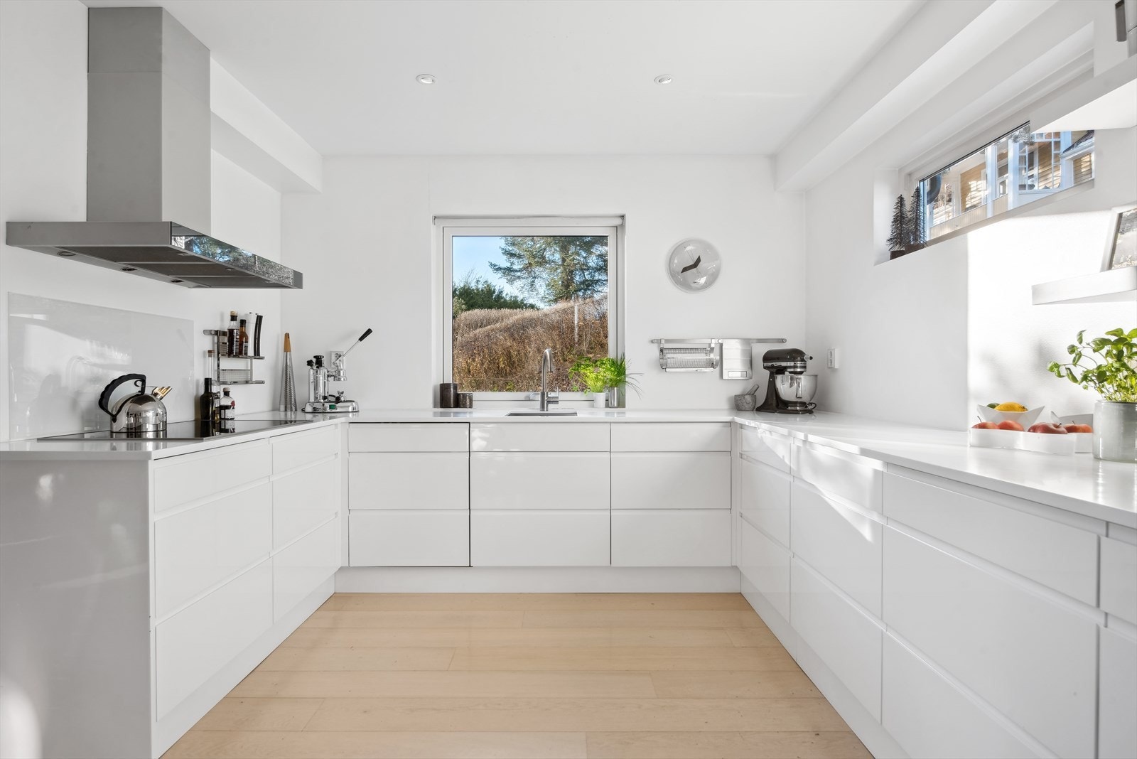 Lyst og romslig kjøkken med skyvedør til eget spiskammers innenfor. Galleribilde