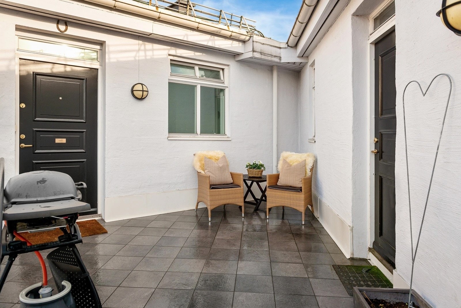 Felles svalgang med sittegruppe og grill rett utenfor inngangsdøren. En skjermet uteplass som deles med få naboer Galleribilde