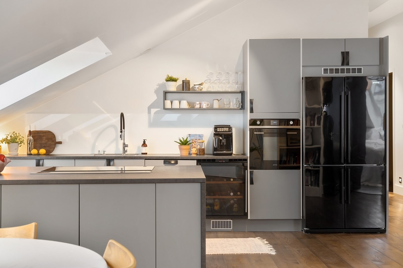 Lekkert HTH kjøkken fra 2017 med glatte fronter og håndtak i skinn - benkeplate med innfelt oppvaskkum og svingbart blandebatteri Galleribilde