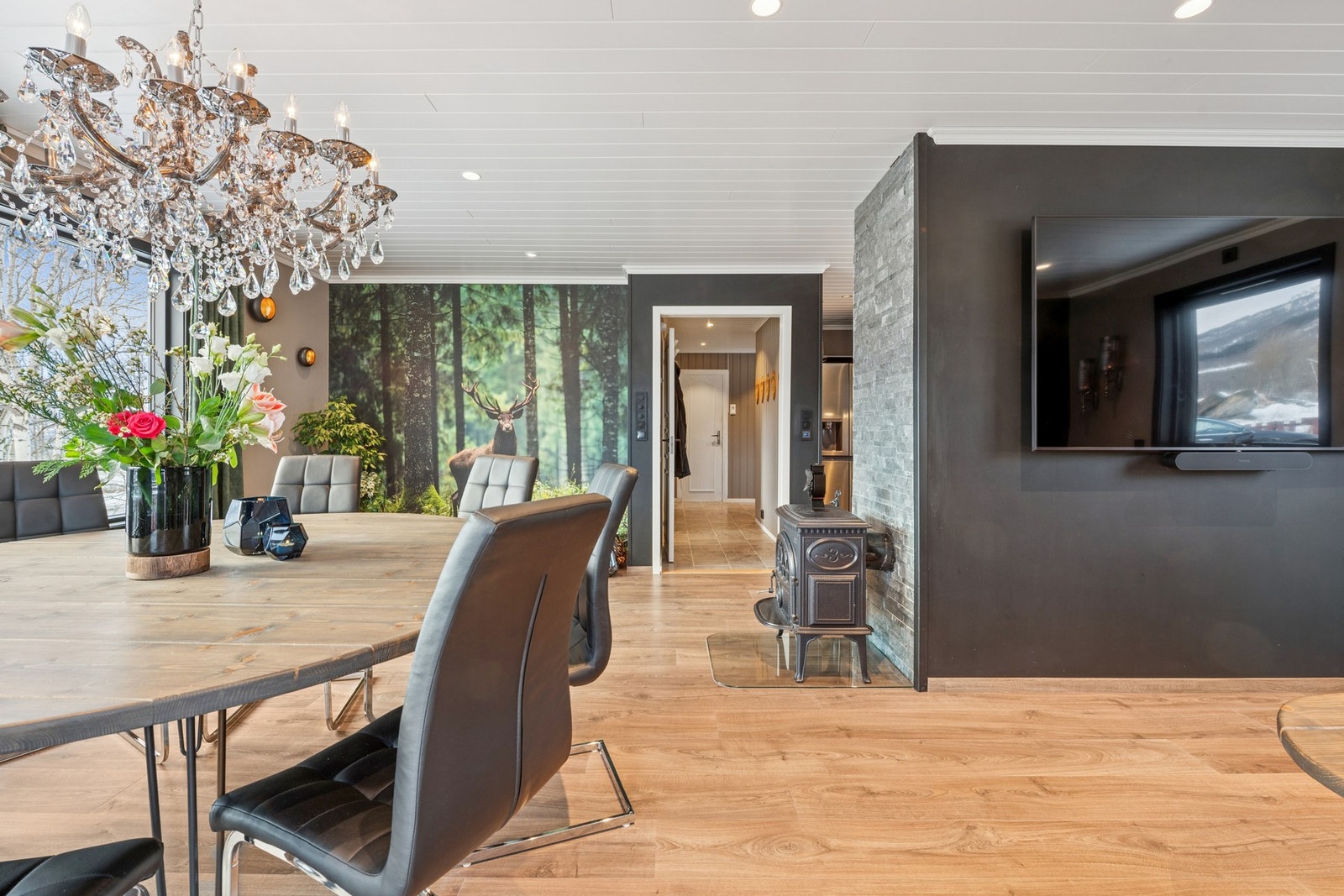 Stue med peisovn som bidrar til lun atmosfære. Gulvvarme i stue, spisestue og kjøkken sørger for behagelig og energieffektiv oppvarming. Galleribilde