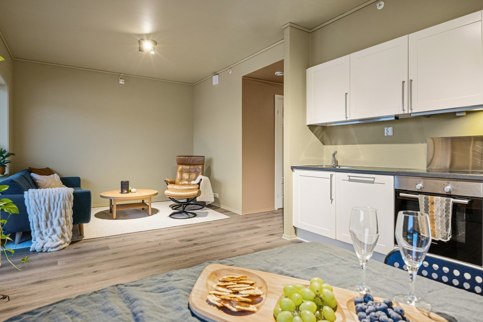 Den åpne stue/kjøkkenløsningen gjør det sosialt å lage mat og praktisk å servere. Galleribilde