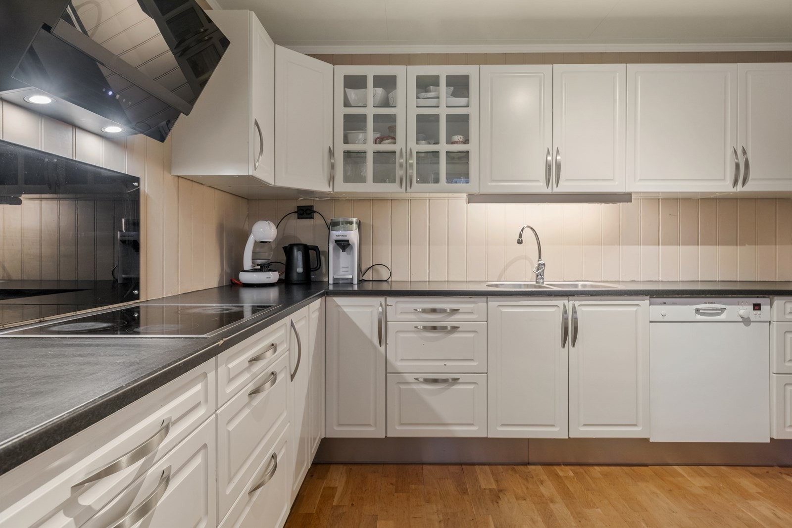 Kjøkkenet har en tidløs innredning profilerte fronter, noen glassfronter og laminat benkeplate. Galleribilde