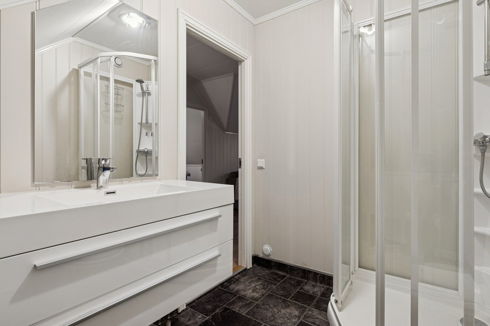 Dusjkabinett og flislagt gulv med varmekabler gir praktisk våtromsløsning. Galleribilde