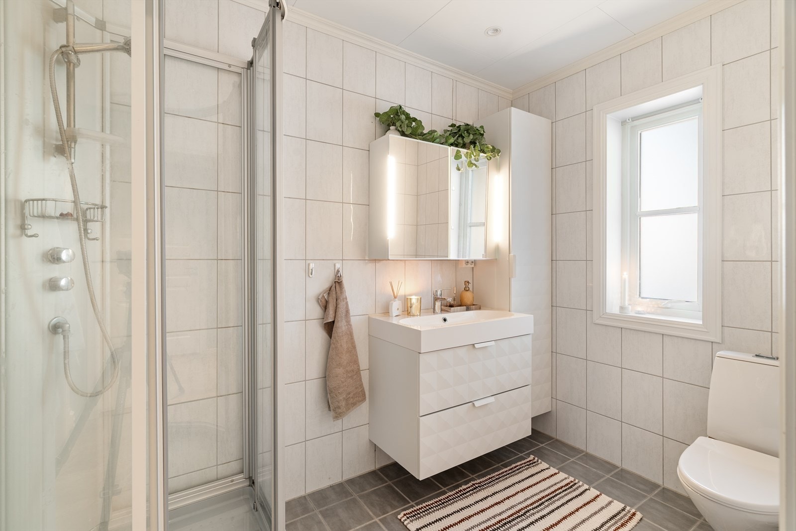 Badet har varmekabler i gulv, samt flott og tidløs baderomsinnredning Galleribilde