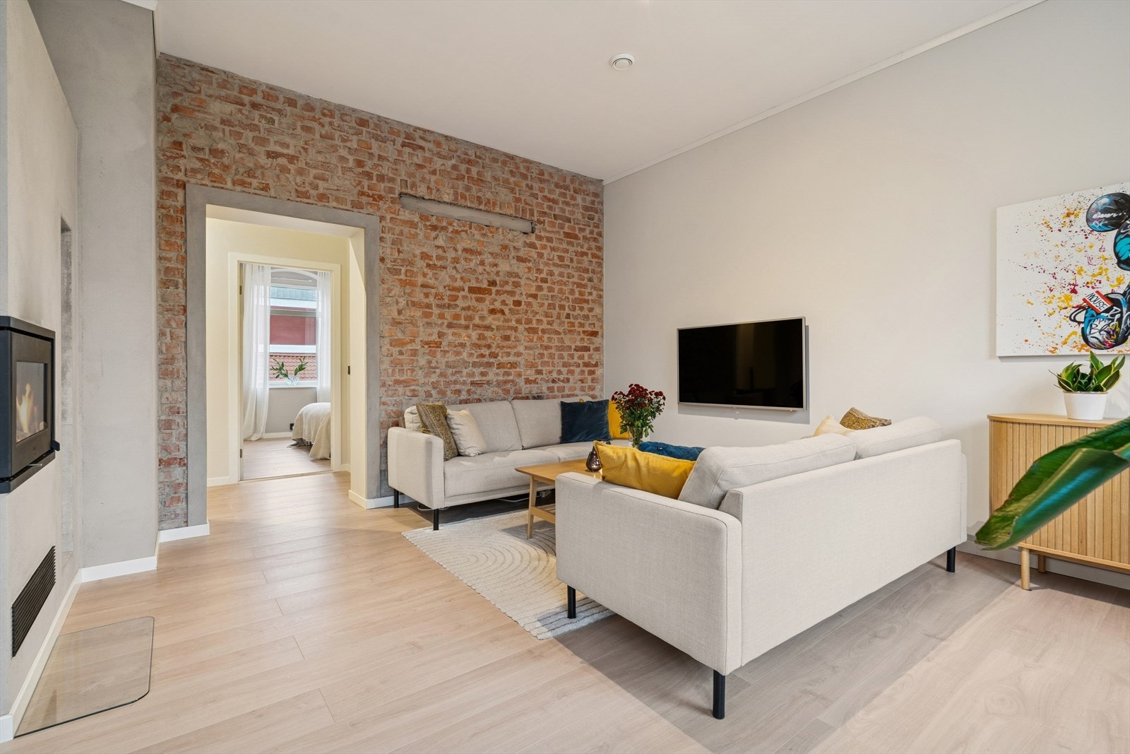 Den originale teglsteinsveggen gir rommet særpreg og tilfører en rustikk og urban stil til det moderne interiøret. Galleribilde