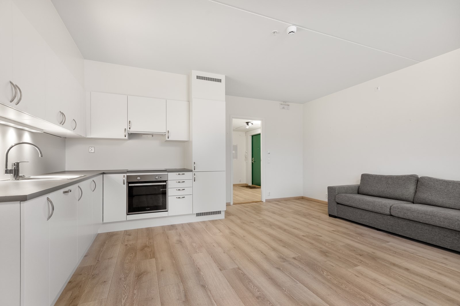 Kjøkkeninnredning fra Aubo med hvite, glatte fronter og mørk benkeplate i laminat. Galleribilde