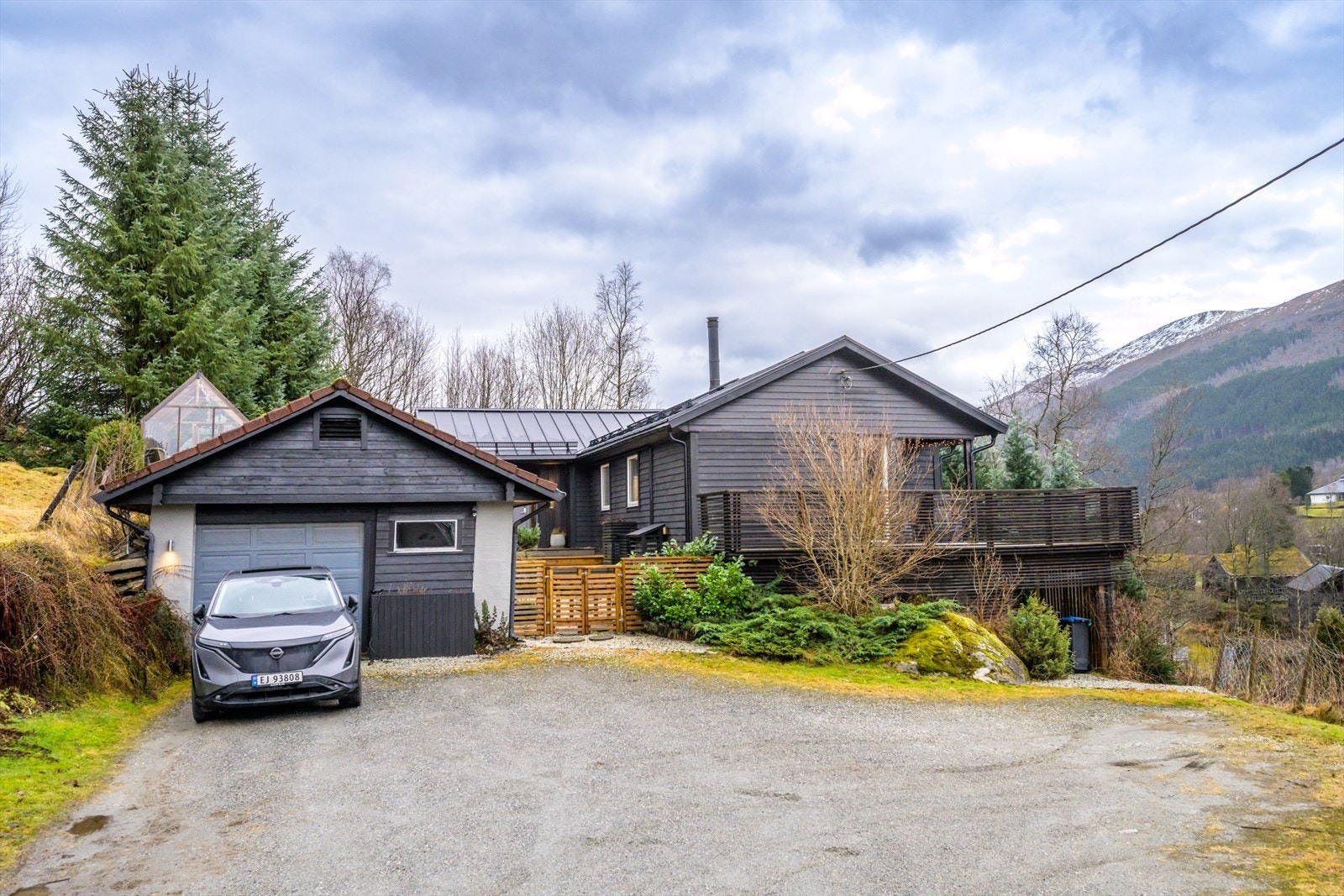 Garasjen ble oppført i 1991 og har enkel port og sidedør. Forran huset og garasjen er det god parkeringsplass til flere biler. Galleribilde