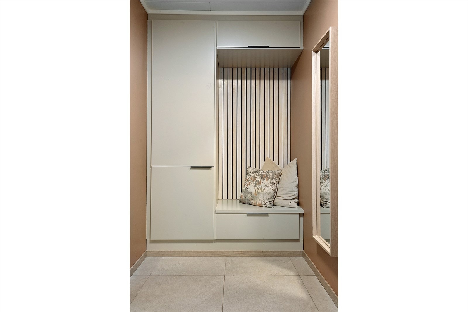 Garderobeinnredningen har spilevegg, skuffer, skap og benk. Galleribilde