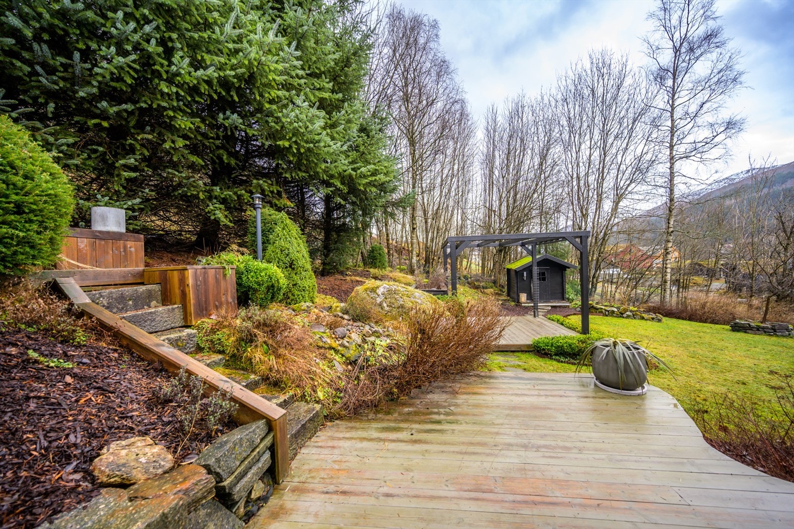 Tomten på ca. 1 160 kvm. er stor og pent opparbeidet med plen, planter, blomsterbed, drivhus, paviljong og plattinger. Galleribilde