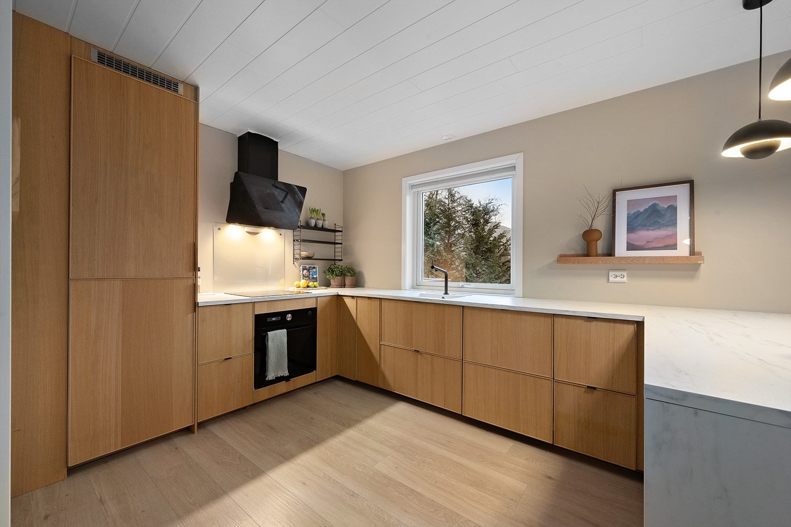 Huset har ett stilrent kjøkken fra IKEA med moderne fronter. Galleribilde