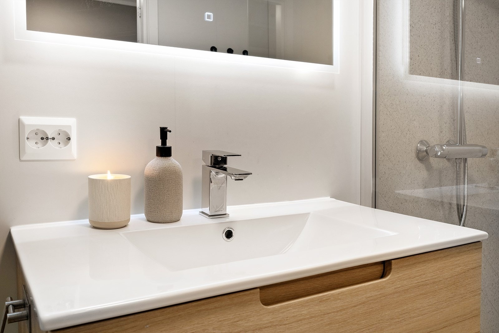 Badet har heldekkende servantplate og speil med bakgrunnsbelysning. Galleribilde