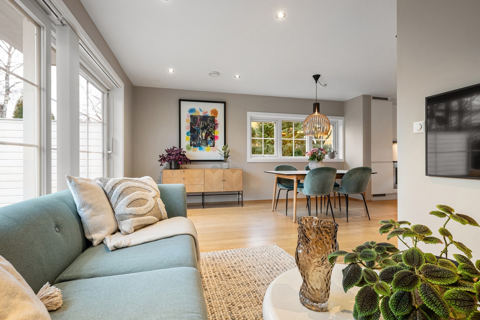 Oppholdsrommet har en smart L-løsning som gir en naturlig skjerming mellom stue og kjøkken. Galleribilde