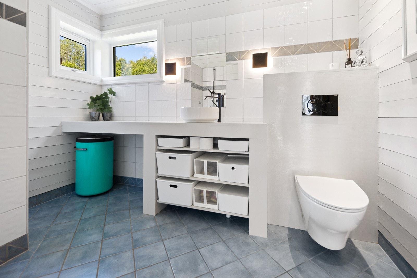 Flislagt baderom i første etasje, innredet med dusjnisje, klosett og servant med hyller og plass til skittentøyskurv samt stang til tørking av tøy. Galleribilde