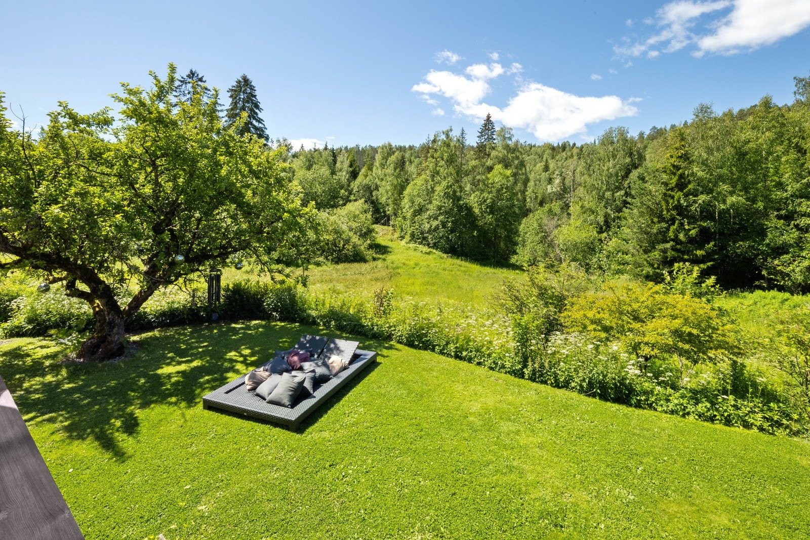 Hagen er pent opparbeidet med gressplen og beplantninger. Galleribilde