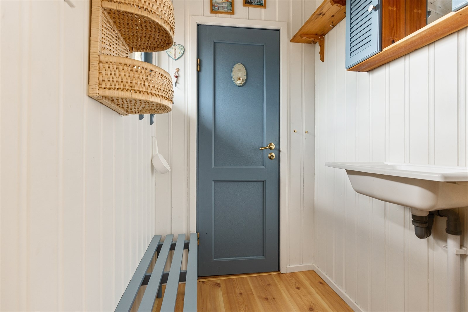 Enkelt vaskerom med vask, speilskap og benk. Galleribilde