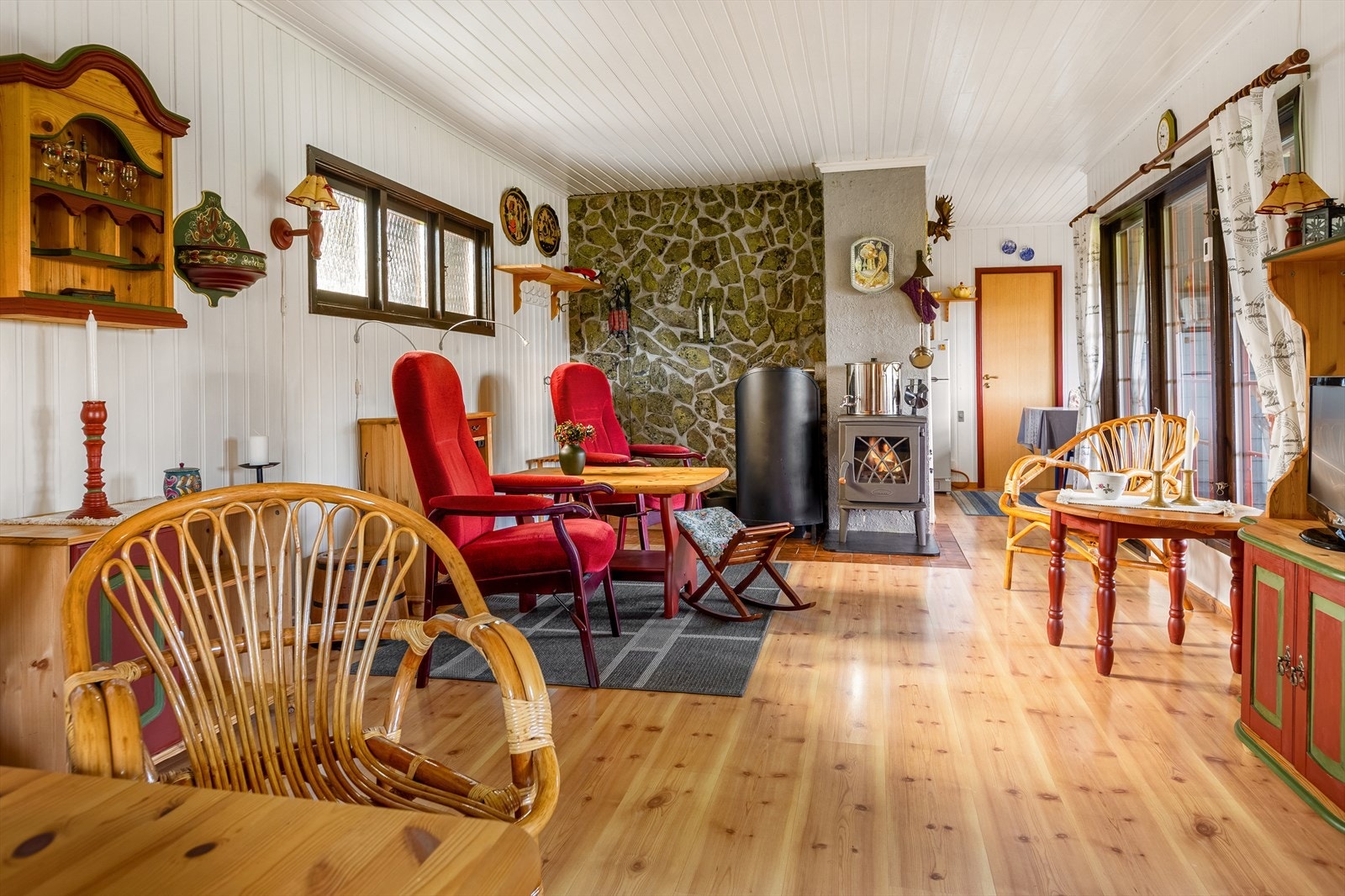 En peisovn med glassdør er en god varmekilde i rommet, og gir et fint innsyn til flammene. I tillegg er det montert en Wallas parafinbrenner med oppringningsfunksjon for fjernstyring. Galleribilde