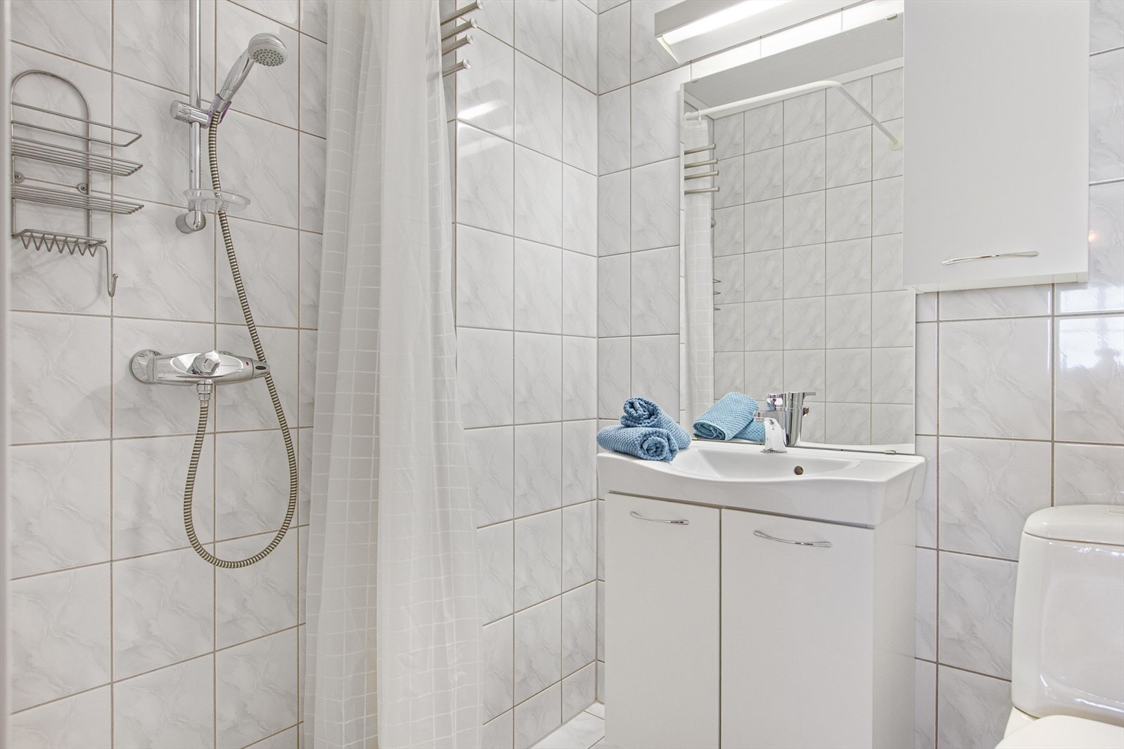 Bad 2 med servantinnredning, toalett og dusjnisje med forheng. Galleribilde