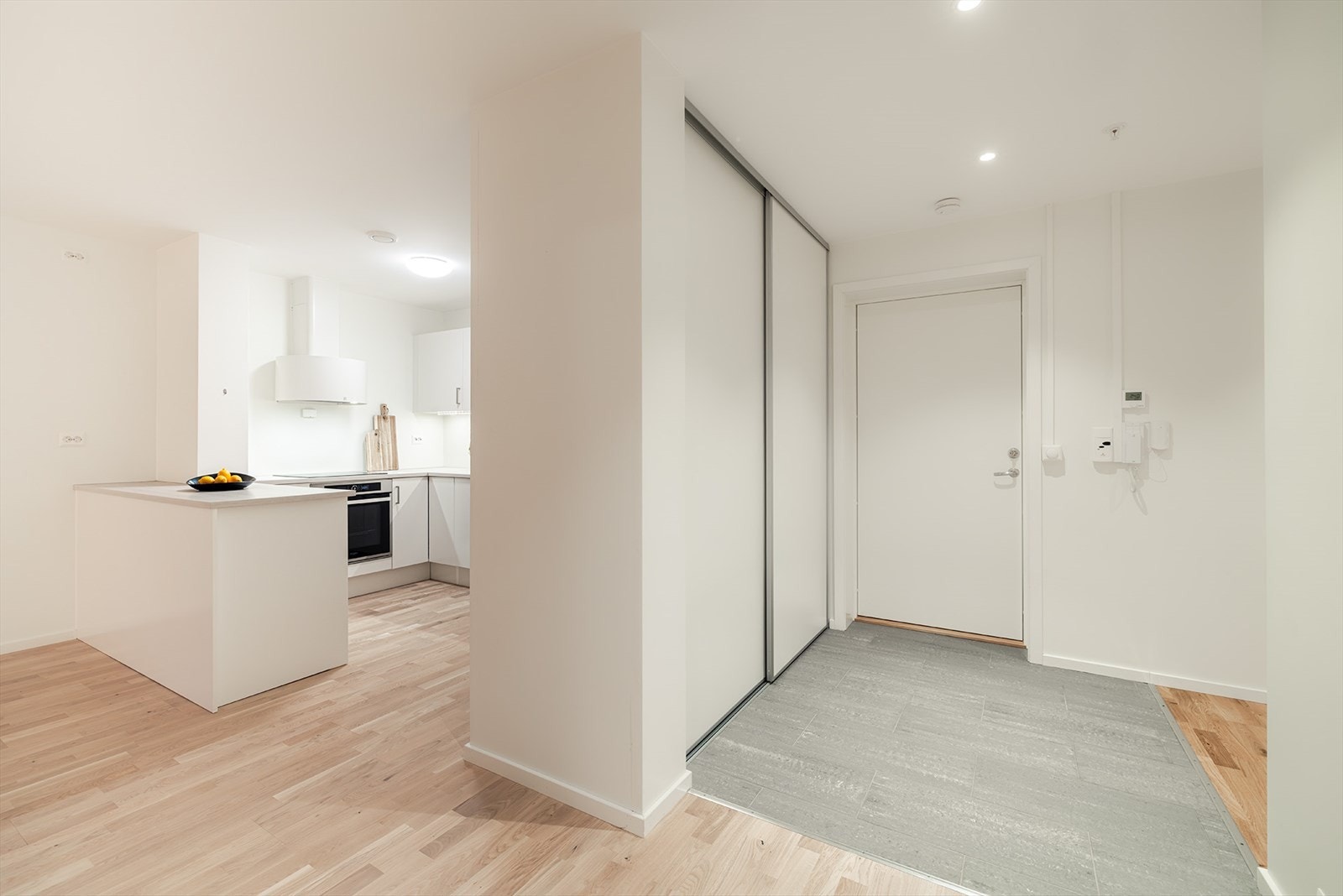 Flislagt gulv og romslig skyvedørsgarderobe i inngangspartiet. Galleribilde