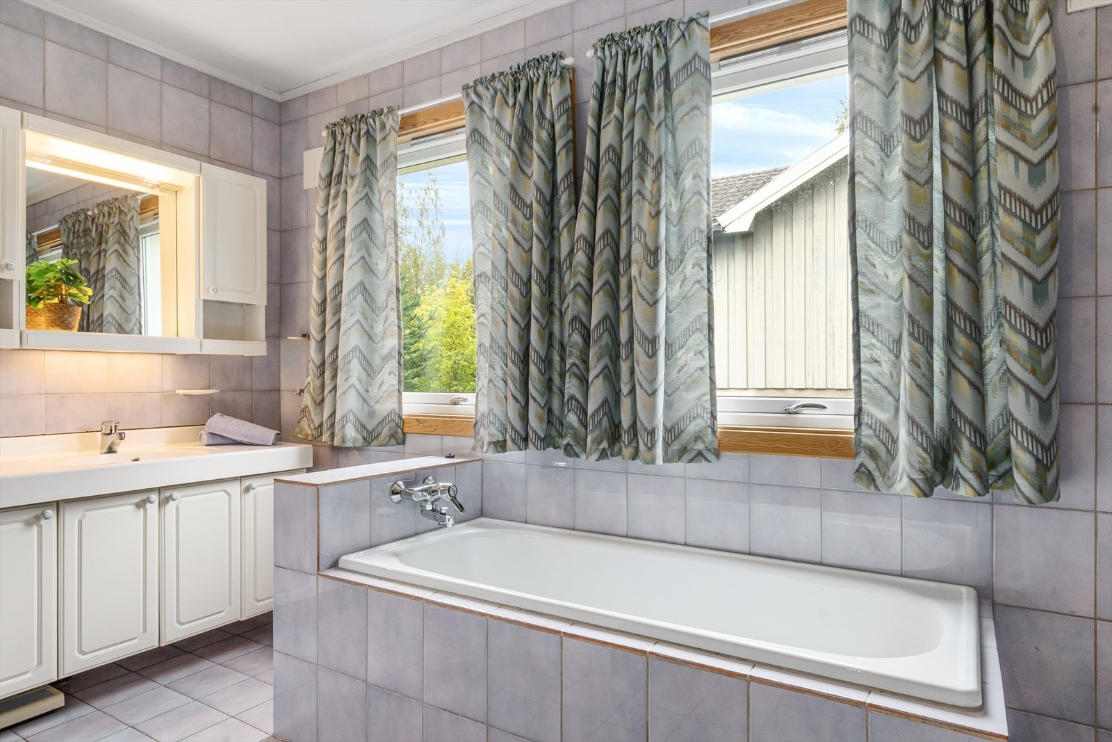 Innholdsrikt bad med badekar og godt med skapplass. Galleribilde