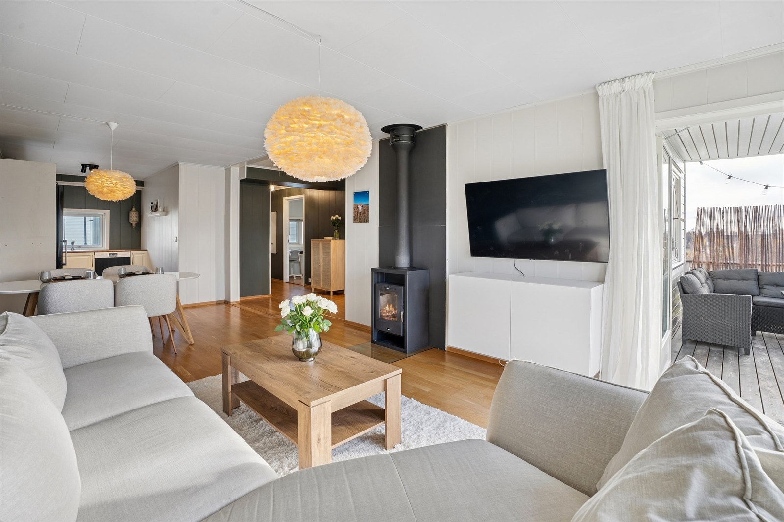 Den åpne løsningen mellom stue og kjøkken skaper en lys og sosial atmosfære Galleribilde