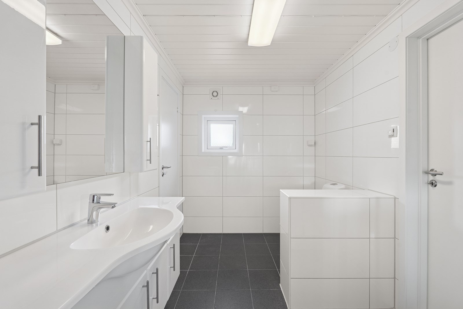 Rommet er ventilert med mekanisk ventilasjon å vegg. Rommets innvendige overflater består av fliser på gulv og vegg og malt MDF panel i tak. Galleribilde