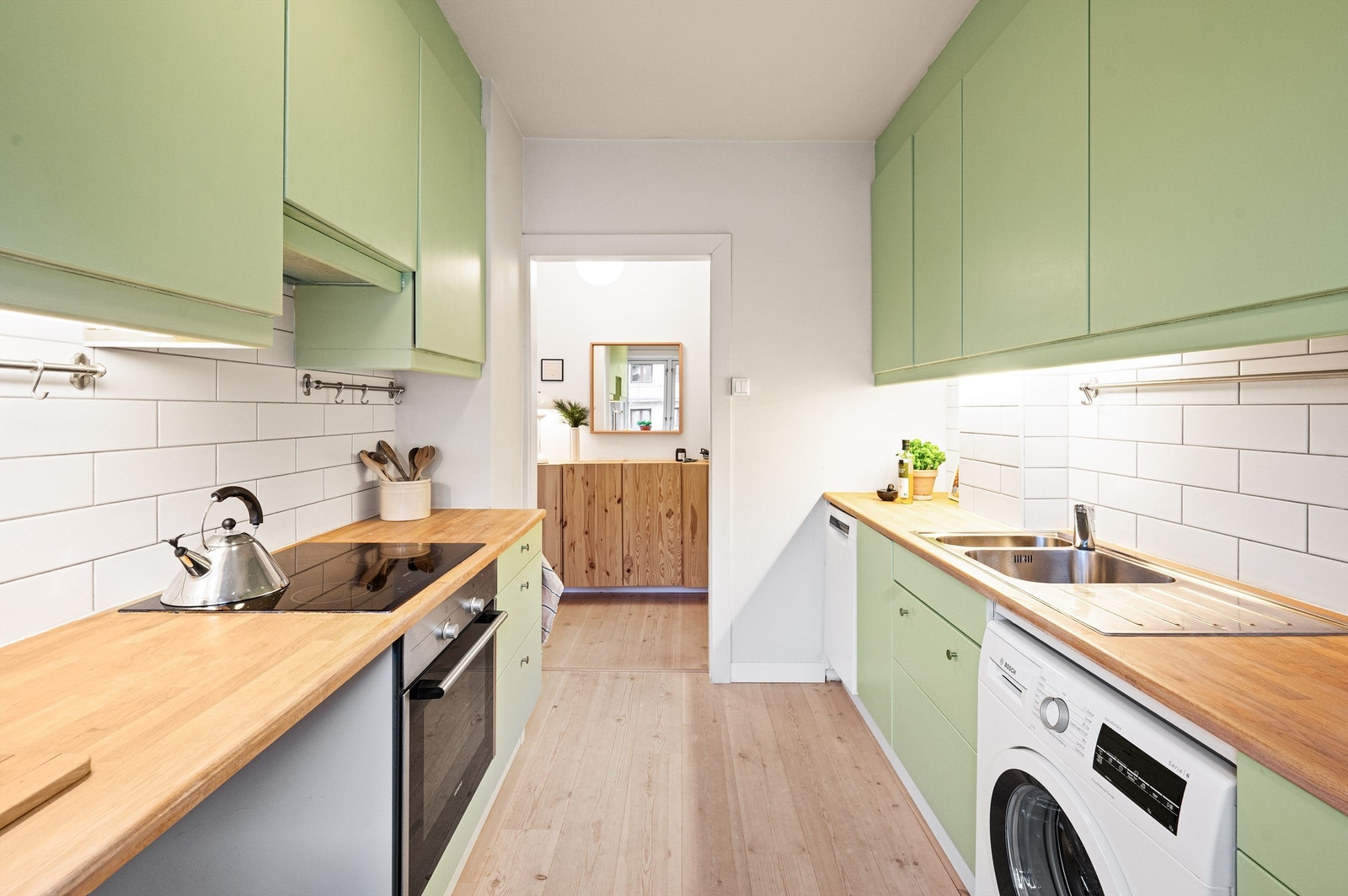 Separat kjøkkenløsning med god benke- og skapplass, samt opplegg for vaskemaskin. Galleribilde