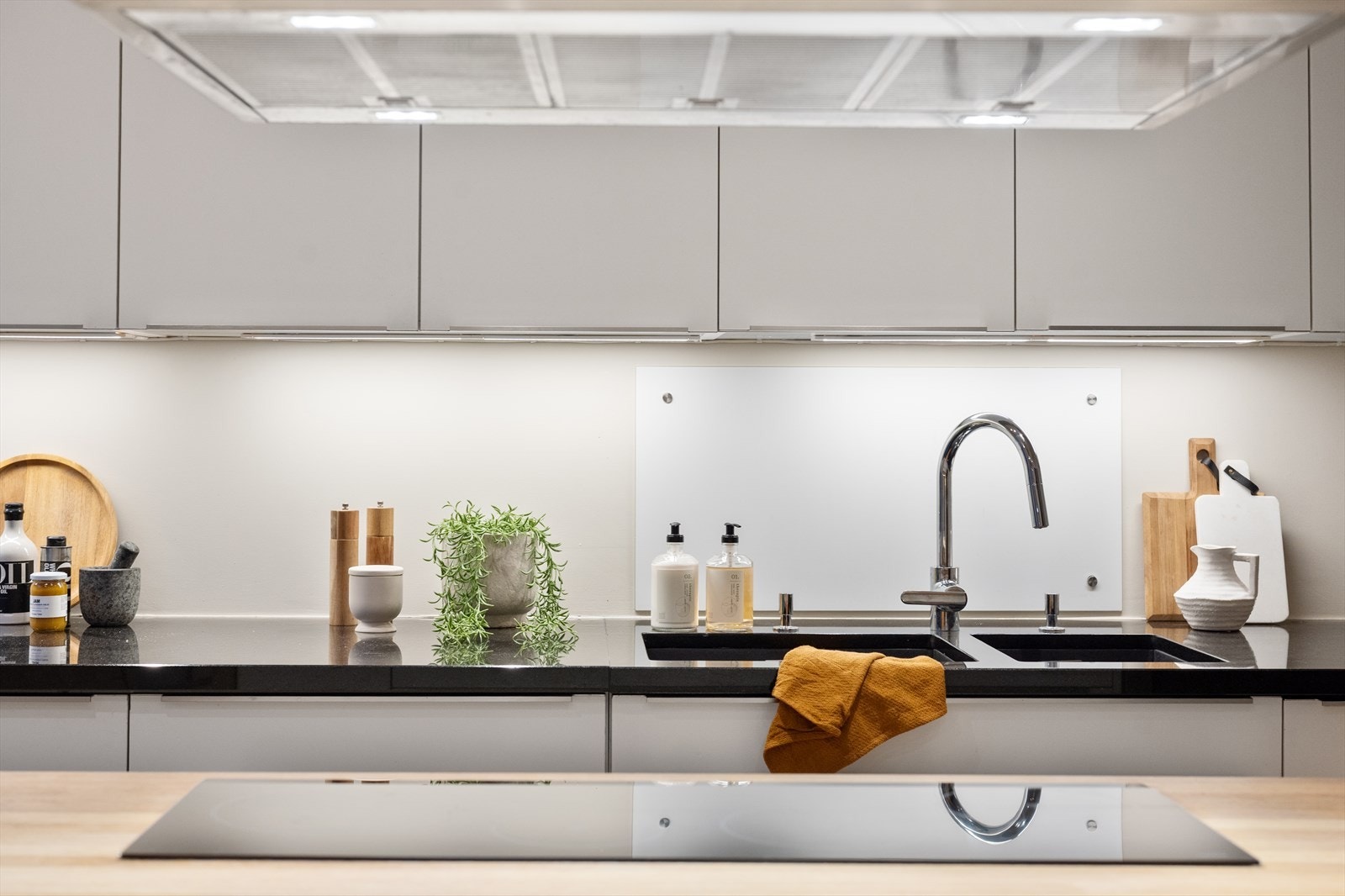 Kjøkkenet er innredet med glatte fronter og benkeplate i slitesterk komposittstein. Kjøkkenøy med heltre benkeplate. Galleribilde