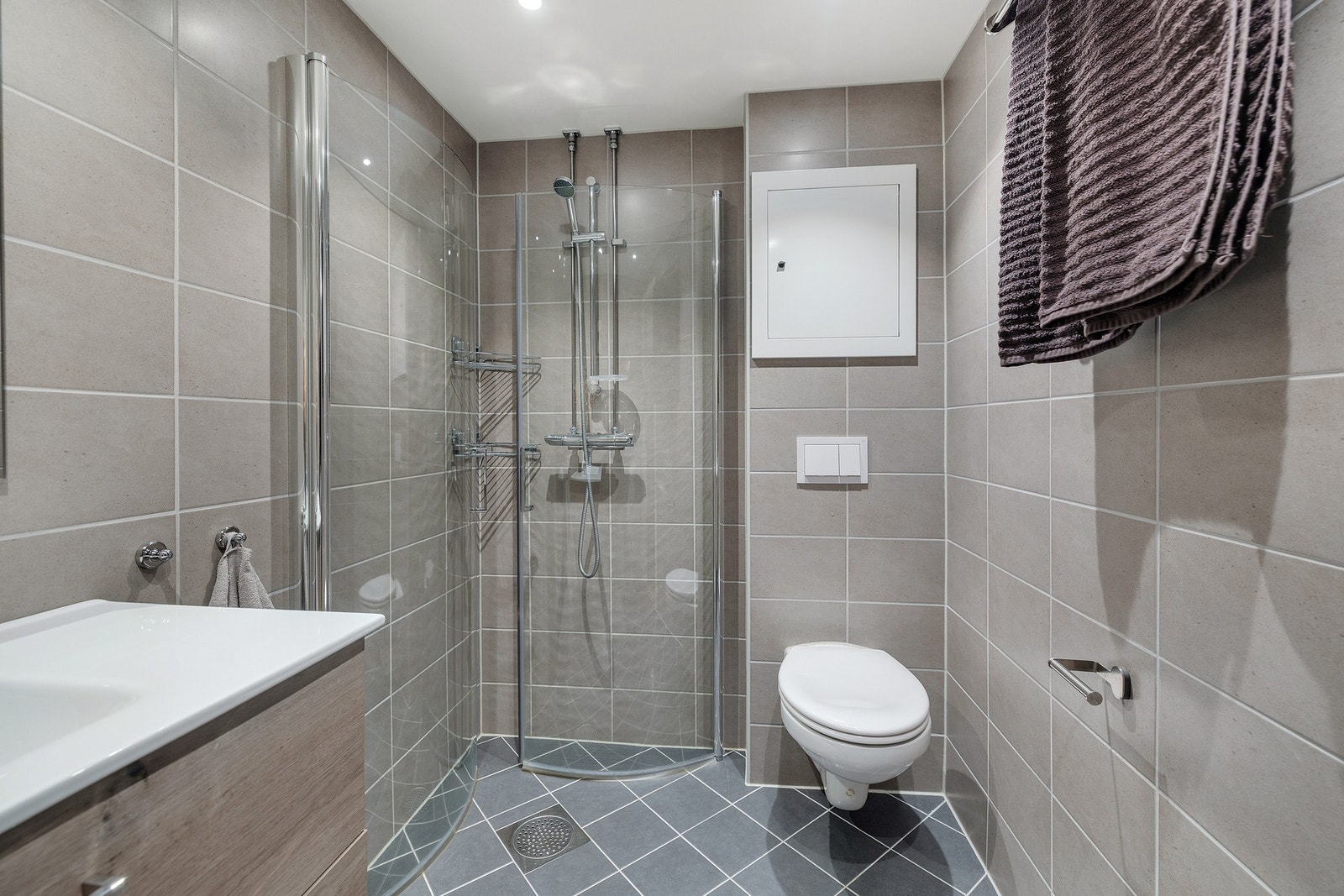 Dusjhjørne med glassdører og vegghengt toalett Galleribilde