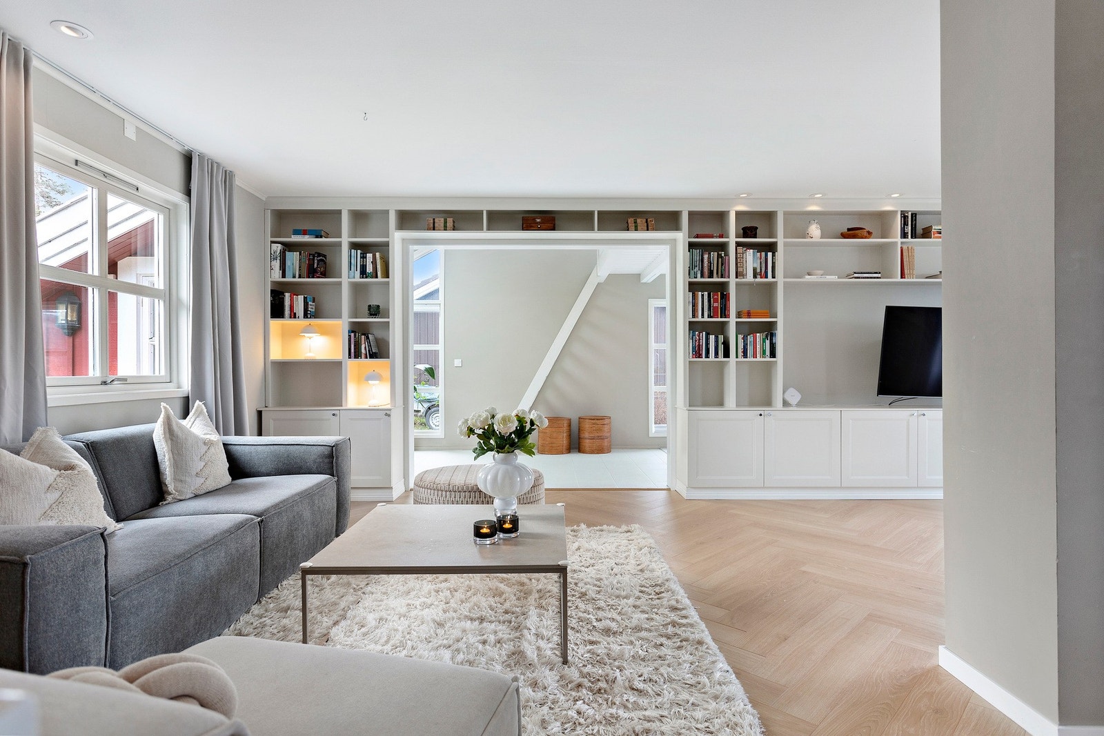 Lekker plassbygget bokhylle med skap som går over hele endeveggen i stuen. Galleribilde