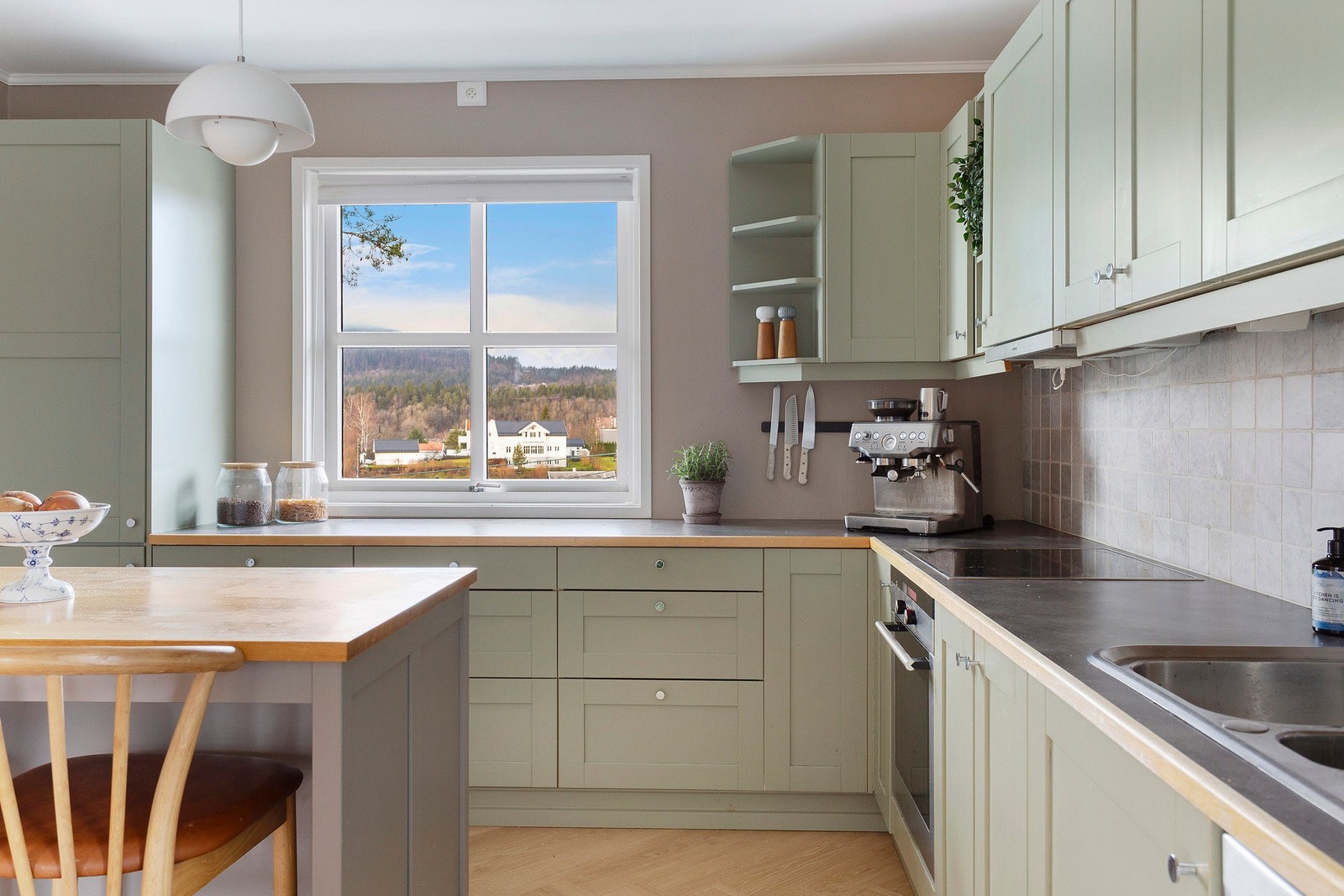 Lyst og lekkert kjøkken med stilren innredning, integrerte hvitevarer og rikelig med skap- og benkeplass. Galleribilde